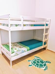 a white bunk bed in a room with a turtle rug at La Stella Marina in Porto Recanati