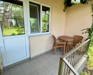 un porche con mesa y sillas junto a una puerta en Ассоль en Koblevo
