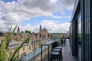 a balcony with stools and a view of a city at The Store in Oxford