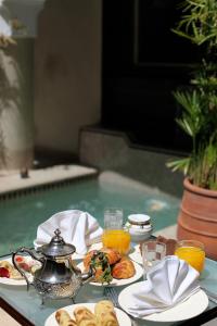 - une table avec un plateau de nourriture et du jus d'orange dans l'établissement Riad Dar Ten, à Marrakech