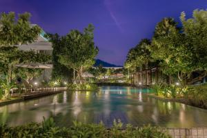- une piscine dans un complexe la nuit dans l'établissement Stay Wellbeing & Lifestyle Resort, à Rawai Beach