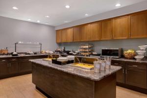 una cocina con una barra con comida. en Homewood Suites by Hilton Lackland AFB/SeaWorld, TX, en San Antonio