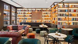 a library with couches and tables and bookshelves at Hilton Dresden an der Frauenkirche in Dresden