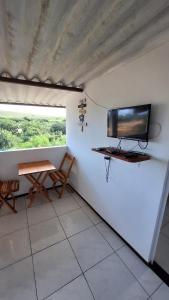 杰里科科拉Pousada Maria Sara的房间里有一张桌子和一台挂在墙上的电视
