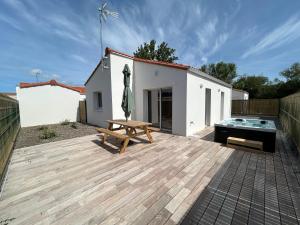 a backyard with a picnic table and a tub at Maisons Phoenix in Saint-Jean-de-Monts