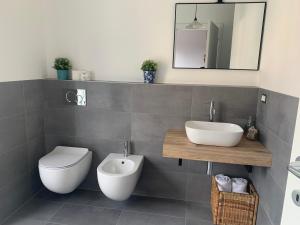 uma casa de banho com um lavatório, um WC e um espelho. em Milano 71 em Milão