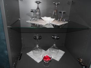 a glass shelf with two wine glasses on white napkins at Siris Hotel in Nova Siri Marina