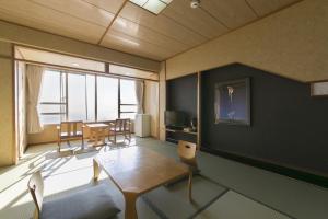 sala de estar con mesa, sillas y ventana grande en Tennomaru, en Gamagori