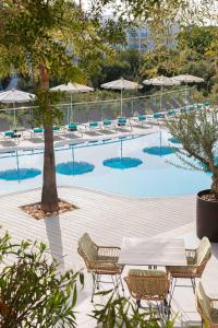 una piscina con sedie, tavoli e ombrelloni di MarSenses Natura Olea Hotel a Cala d´Or