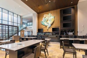 德梅因Hilton Des Moines Downtown的用餐室配有桌椅,墙上挂有绘画作品