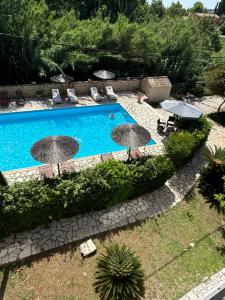 an outdoor swimming pool with umbrellas and chairs at Charieta n.8 in Áno Korakiána