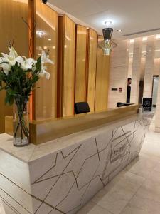 a reception desk in a lobby with a vase of flowers at Yas Island in Abu Dhabi