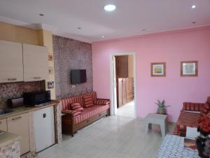 a living room with pink walls and red couches at Nour in Sousse
