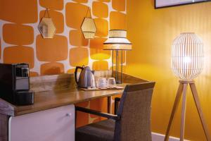 a desk with a lamp and a chair in a room at Aiden by Best Western Paris Roissy CDG in Roissy-en-France