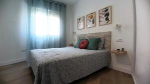 a bedroom with a bed with green pillows and a window at San Fausto in Aguadulce