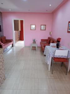 a living room with pink walls and a table and chairs at Nour in Sousse