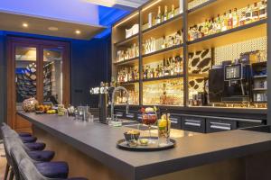 a bar in a restaurant with a counter and chairs at Best Western Premier Le Chapitre Hotel and Spa in Remiremont
