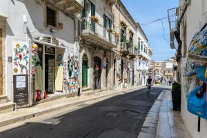 a person riding a bike down a street with buildings at Appartamento Vintage con Balcone by Wonderful Italy in Ostuni