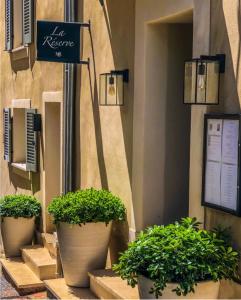 a sign on the side of a building with potted plants at La R&eacute;serve by Mougins Luxury Retreats in Mougins