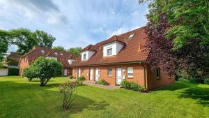 ein großes Backsteinhaus mit einem Rasenhof in der Unterkunft Zur Hanse Wohnung 1 4 in Zingst