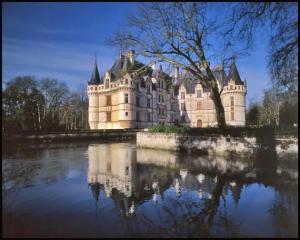 un castillo sentado sobre un cuerpo de agua en Chalet 3 étoiles - Parc aquatique - eebbhc, en Moncontour-de-Poitou