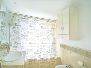 a bathroom with a shower curtain with writing on the wall at Banana Beach in Marbella