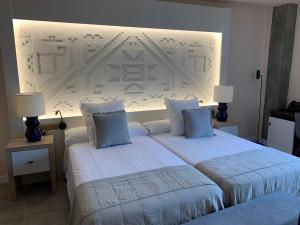 - une chambre avec 2 lits dotés d'oreillers bleus dans l'établissement Hotel Hacienda del Cardenal, à Tolède