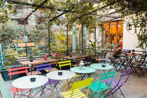 a patio with tables and chairs in a garden at Ostello Bello Milano Centrale in Milan