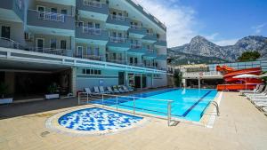 a swimming pool in front of a building at Nex Royal Beach in Antalya