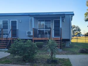 a small house with a porch and a deck at Moree Tourist Park in Moree