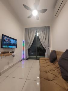 a living room with a couch and a ceiling fan at Edumetro Homes in Subang Jaya +2 photos