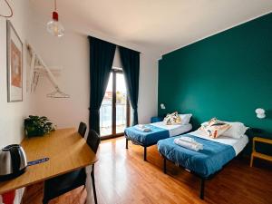 Pokój z 2 łóżkami, biurkiem i stołem w obiekcie Ostello Bello Milano Centrale w Mediolanie