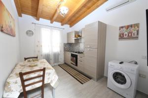 a kitchen with a table and a washing machine at AL Quadrifoglio in Terrasini