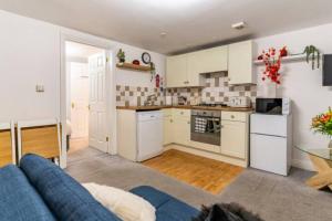 a kitchen with a blue couch in a living room at The Nook, Cosy 1BR in Blandford, Dorset in Blandford Forum