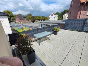 un patio con banco y parque infantil en FeWo Banter Eck Mini Loft, en Wilhelmshaven 3 fotos más