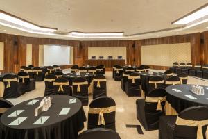 a conference room with black tables and chairs at Hotel Mayura in Raipur