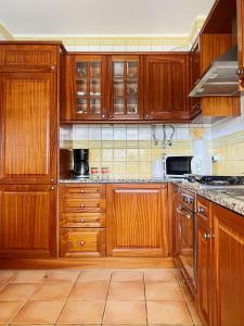 cocina con armarios de madera y horno con fogones en Benagil Beach House - Yasmin en Lagoa