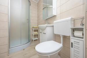 a bathroom with a toilet and a sink and a shower at Apartmani Leo centar in Crikvenica +24 photos