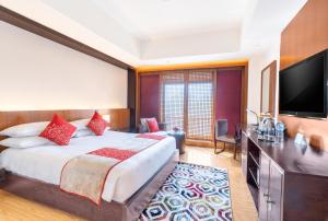 a hotel room with a bed and a flat screen tv at The Soaltee Kathmandu in Kathmandu