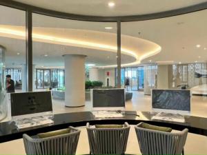 a lobby with a desk with two monitors and chairs at The Sóng Vũng Tàu Melon Home in Vung Tau