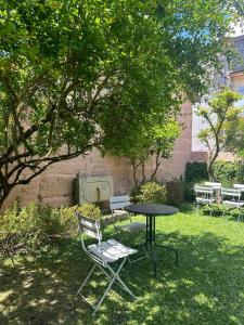 a table and chairs sitting in a yard with a tree at Casa do Juncal in Guimarães