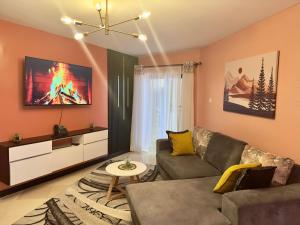 a living room with a couch and a tv at Cozy Home Near Wilson Airport & Giraffe Center in Nairobi