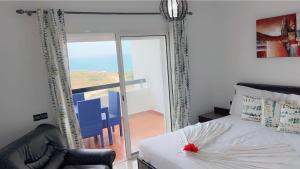 a bedroom with a bed and a sliding glass door at Appartement 3 chambres vue mer et golf in Asilah