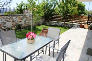a patio with a table and chairs in a yard at Kassiani House in Theológos