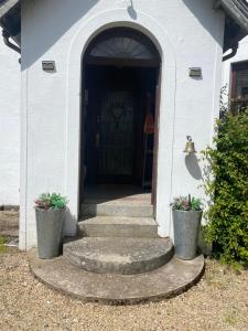 an entrance to a white building with stairs and a door at Fox House Thirdpart Farm in Beith