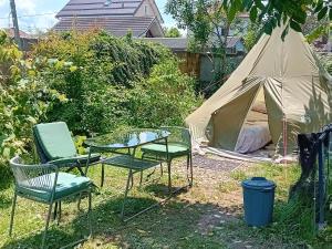 ein Zelt, zwei Stühle und ein Glastisch im Hof in der Unterkunft camping under the walnut in your own tent in Ljubljana