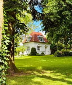 エッカーンフェルデにあるSimonの緑の芝生の上に赤い屋根の白い家