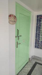 a green door in the corner of a room at Axom Aura in Tezpur
