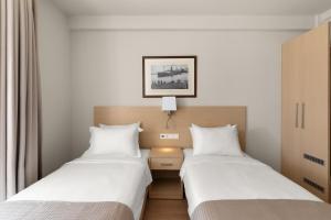 two beds sitting next to each other in a room at Gallery Central Piraeus Port in Piraeus