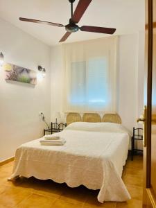 a bedroom with a bed with a ceiling fan at Casa Pedro in Benaoján +37 photos